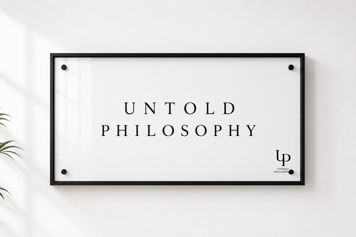 A minimalist framed wall art print with the text 'UNTOLD PHILOSOPHY' in black serif lettering on a white background, enclosed in a thin black frame and mounted on a white wall.